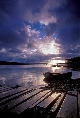 Sunrise over Kielder water with jetty and fishing   boat in foreground Northumberland UK
