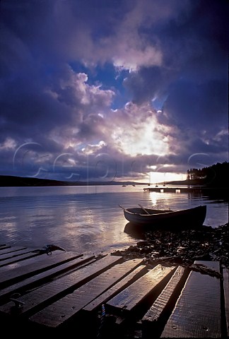 Sunrise over Kielder water with jetty and fishing   boat in foreground Northumberland UK