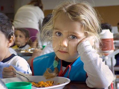 Solemn kindergarten girl pauses during her school   lunch