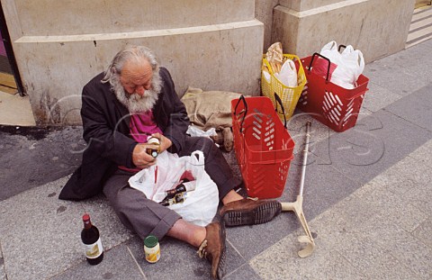 Elderly disabled alcoholic examines his latest purchases
