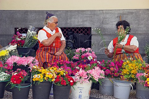 Flower sellers in traditional costume outside the   Mercado dos Lavradores Funchal Madeira Portugal