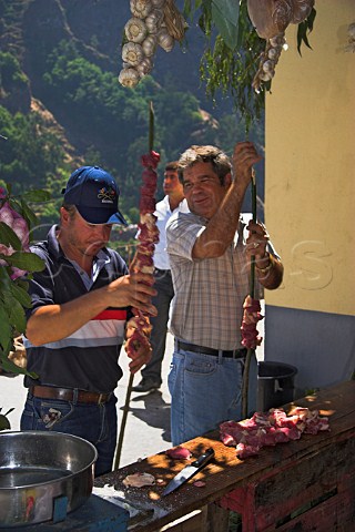 Preparing giant skewers of steak for barbequeing   during a festival at Curral das Freiras Madeira   Portugal