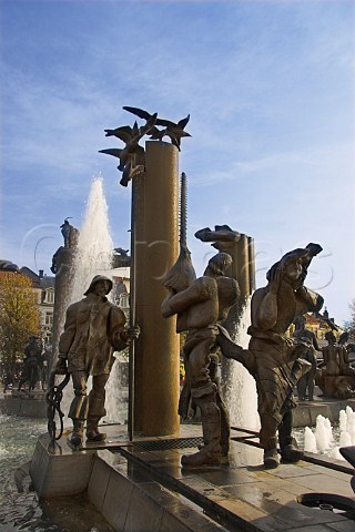 Statue of fishermen next to a fountain in tZand   Brugge Belgium