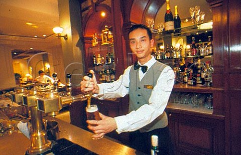 Barman pouring a beer in a hotel bar Hanoi  Vietnam