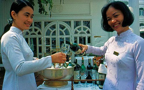 Wine waitresses pouring wine at the Metropole hotel  Hanoi Vietnam