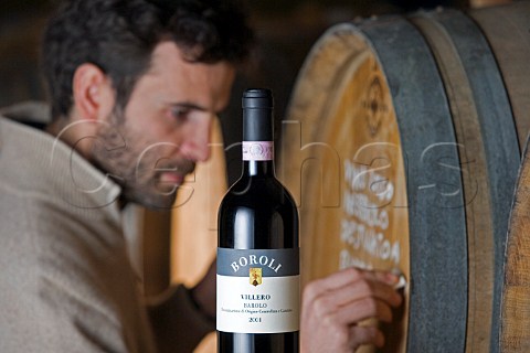 Silvano Boroli writing on barrel of Villero Barolo   in cellar of Vini Boroli Madonna di Como near Alba   Piemonte Italy