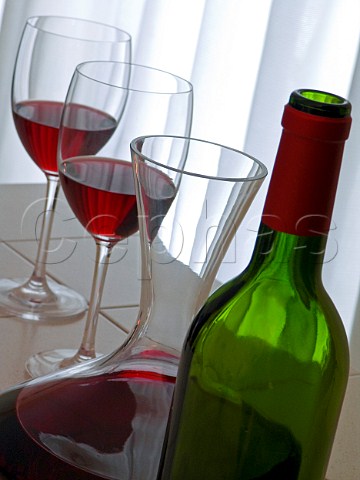 Glasses of red wine with bottle and decanter