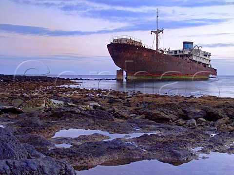 Rusting shipwreck lies in shallow water cove in   Lanzarote Canary Islands Spain