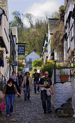 Tourists descending the steep cobbled main street in   Clovelly North Devon England