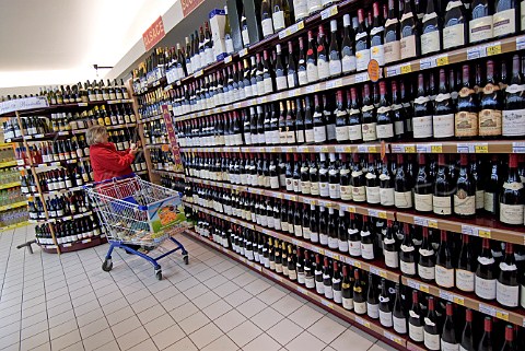 Female shopper the wine section of a supermarket   Cte dOr France