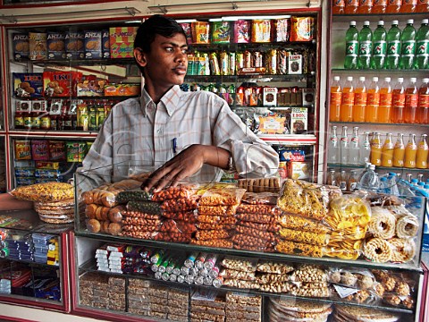 Indian man behind counter in general store Chennai   Madras India