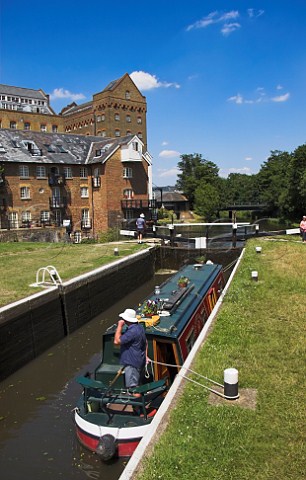 Narrowboat at Coxs Lock on the River Wey Navigation   canal with old mill buildings behind Addlestone   Surrey England