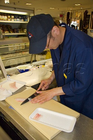Preparing tai sashimi sliced raw sea bream in  the food hall Selfridges London