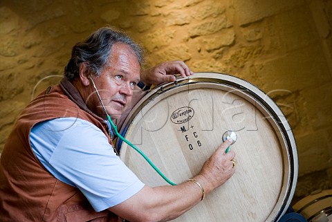 Doctor Alain Raynaud listens to barrel of his 2006   with his stethoscope Chteau Quinault LEnclos   Libourne Gironde France  Saintmilion  Bordeaux