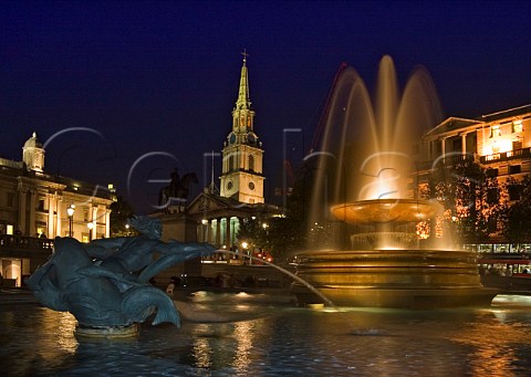 Fountains in Trafalgar Square at night with the church of St MartinintheFields behind London