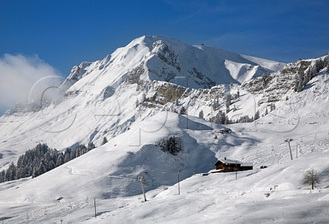Chalet and ski lift by La Duche piste in the ski resort of Le GrandBornand HauteSavoie France