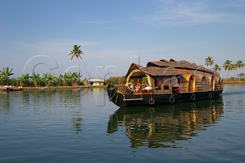 Tourists relaxing and enjoying the sunshine on a private houseboat on the Kuttanad the backwaters of Kerala known as the Venice of the East Kerala India