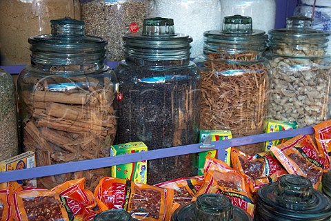 Spices for sale cinnamon sticks black peppercorns and packets of crushed chilli peppers Connemara Market Thiruvananthapuram Trivandrum Kerala India