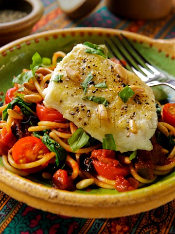Baked cod with pinenuts on spaghetti
