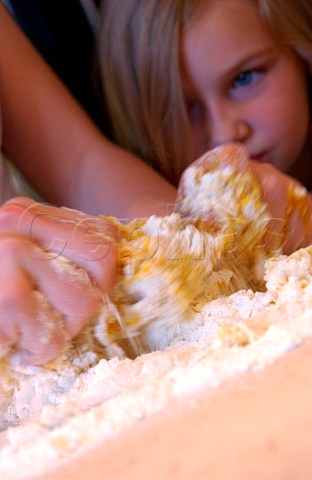 young girl watching her mother make pastry