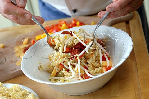 Chef preparing ingredients for a pasta salad