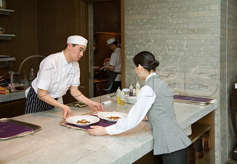 Serving Terrine of braised Kirishima pork pickled girolles quails egg and celeriac pure at Gordon Ramsays Cerise Restaurant Conrad Hotel Tokyo