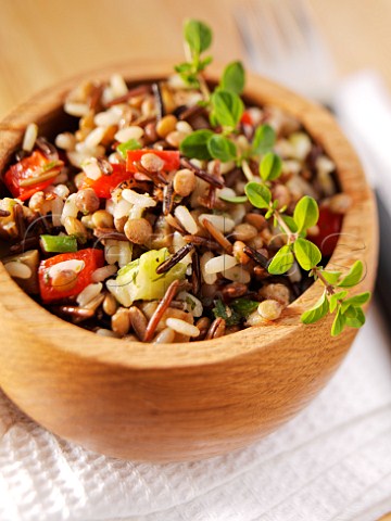 Wild rice and lentil salad with thyme in a wooden bowl