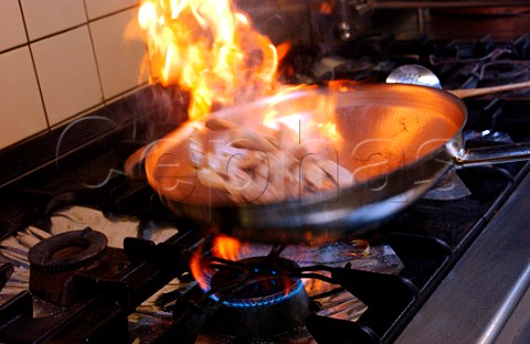 Flambing slices of pork fillet in wok