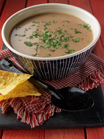 Bowl of refried bean soup with tacos