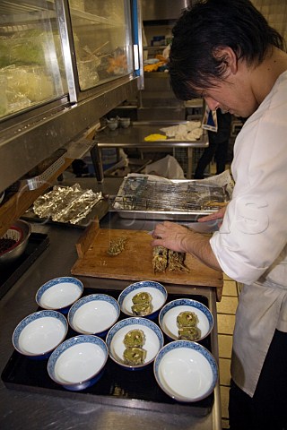 Preparing dishes of tempura soba in a Japanese restaurant