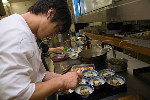 Preparing dishes of tempura soba in a Japanese restaurant