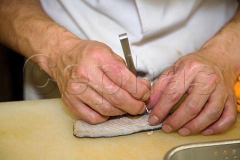 Removing small bones from a dab fillet to be used for sashimi