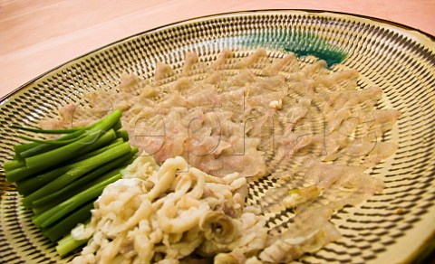 Plate of freshly prepared fugu blowfish sashimi with spring onions