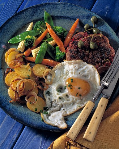 Fried egg and beefburger with vegetables