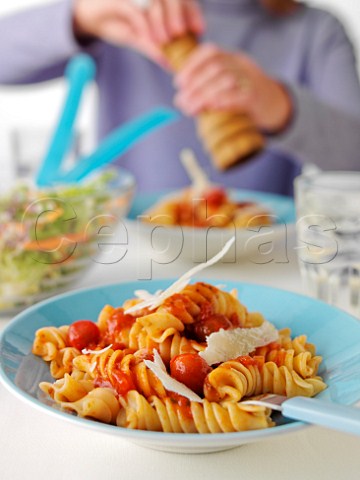Eating meal of fusilloni pasta with tomato sauce