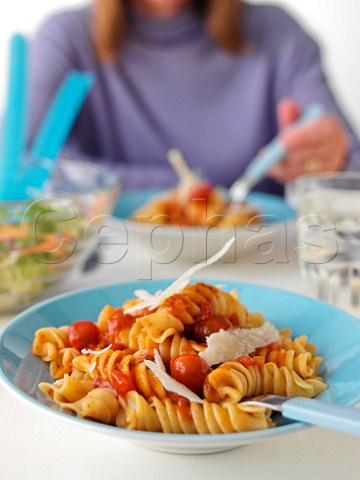 Eating meal of fusilloni pasta with tomato sauce