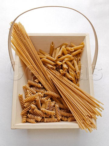 Variety of wholewheat pasta in a wooden basket