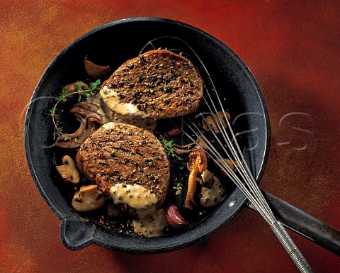 Fillet steak with mushrooms and garlic in a frying pan