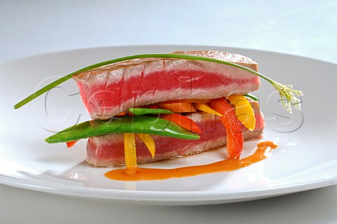 Fried tuna steaks with mangetout and peppers