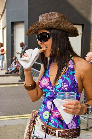Girl eating take away pizza at the Notting Hill Carnival London