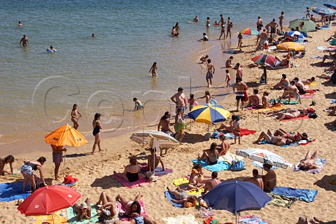People sunbathing by the Mira River estuary at Vila Nova de Milfontes Odemira Portugal