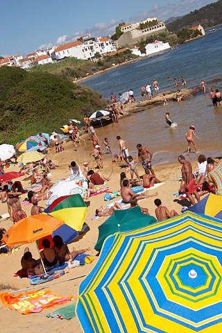 People sunbathing on the beach by the Mira River estuary at Vila Nova de Milfontes Odemira Portugal