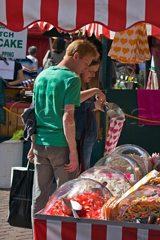 Couple buying confectionery at KingstonuponThames market Surrey