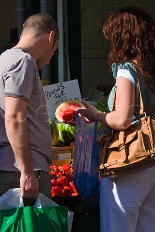 Couple buying peppers at KingstonuponThames market Surrey