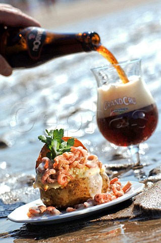 Pouring glass of Rodenbach Grand Cru beer with seafood jacket potato