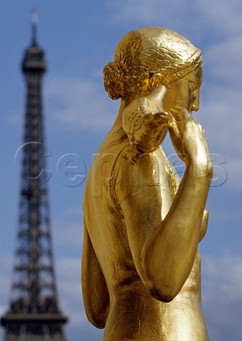 Gilded statue at the Palais de Chaillot in the Trocadro with the Eiffel Tower beyond Paris France
