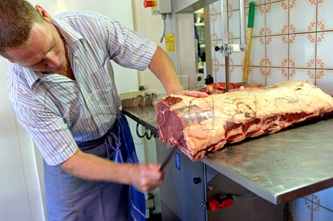 Butcher cutting and cleaning beef ribs