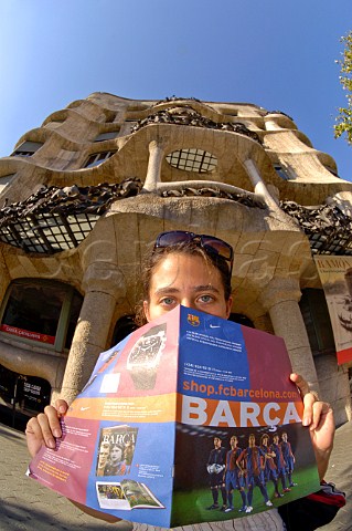 Woman in front of Gaudis Casa Mila La Pedrera  reading La Barca Barcelona football clubs magazine Barcelona Catalonia Spain
