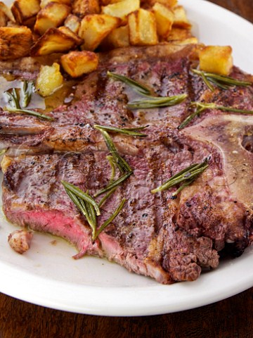 Tbone steak with roasted potatoes and rosemary butter sauce