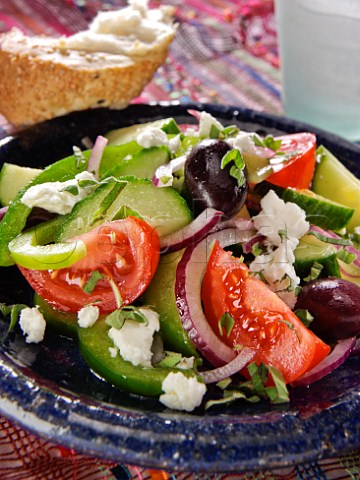 Dish of Greek salad with feta cheese and crusty bread